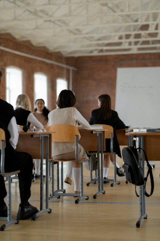 aula con alumnado y encerado blanco al fondo