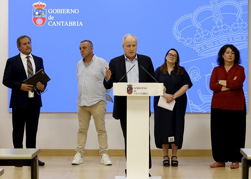 Eduardo Arasti, Consejero de Industria, Empleo, Innovación y Comercio del Gobierno de Cantabria, en atril junto a su equipo alrededor