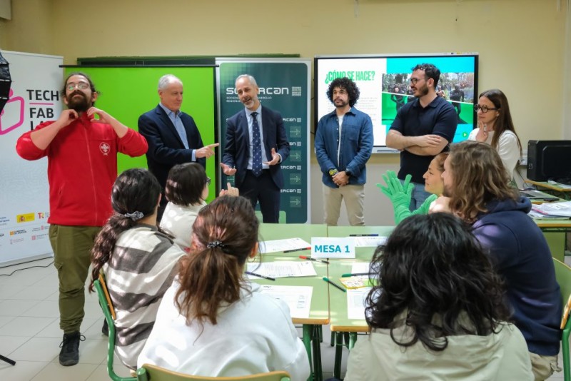 Consejeros, profesional audiovisual, colaborador de CISE y otras personas en un aula con mobiliario, croma y roll up en tonos verdes