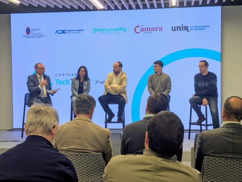 Autoridades a cargo de la presentación del programa sentados en taburetes altos sobre escenario