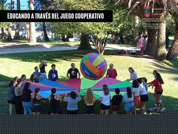 Imagen de personas jugando con un lápiz cooperativo, dibujando un mural entre todas. Portada del folleto del curso Educando a través del juego 